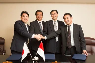 調印後の固い握手を交わす様子