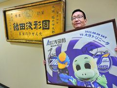 2022年8月6日「浅田飴マッチデー」の記念パネルを持つ代表取締役社長・堀内 邦彦