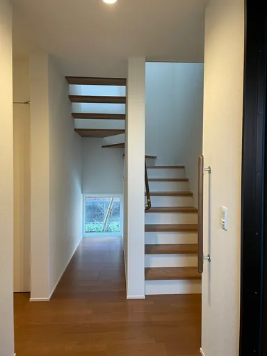 小窓がアクセントになっている階段　上半分はシースルーで下半分は収納に