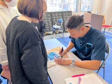 講演会後にサインをもらう参加者たち