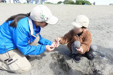 クラフトイベントで参加者とパークコーディネーターが漂着物(貝やマイクロプラスチック)を拾っている様子
