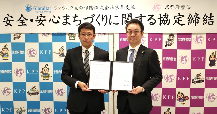 <調印式の様子(左:京都府警察本部 生活安全部長 西山 亮二 様、右:当社京都支社長 日野 好隆)>