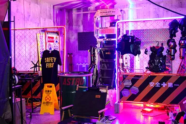 写真中央が「ASTRO」。工事現場のフェンスは戦闘が行われる現場のリアリティーを出すともに安全冊の役割も。極彩色のライトアップが非日常感を高める