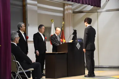 壇上で学長が学位記を読み上げている様子