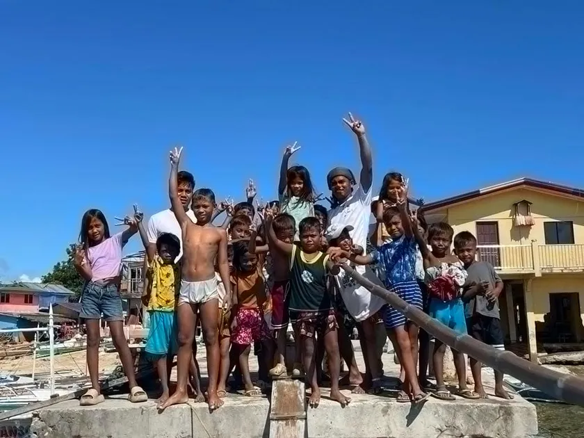 手を振り見送るパンダノン島の子供たち