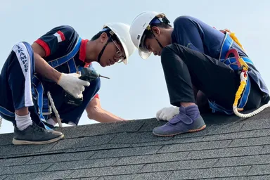 屋根の取り付け作業を行う研修生