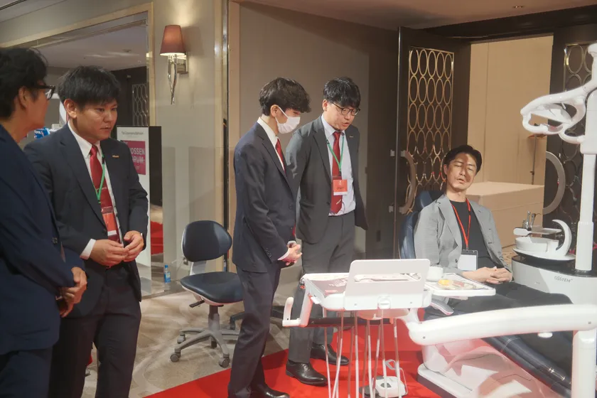 図5:営業社員から最新鋭の歯科用ユニットチェアK5(ケーファイブ)の説明を受ける参加者