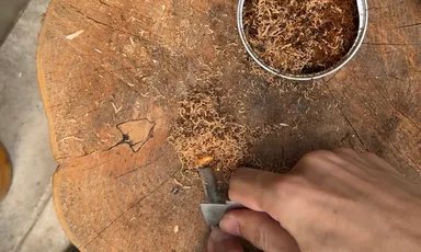 火口をメタルマッチで着火する様子