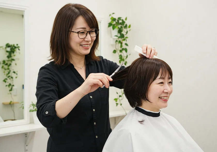 カット中の写真 アイリストとして活躍をしながら、スタイリストを目指せる