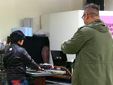 大阪・天満のシンセサイザーショップ「Implant4」店内で、30年以上前に作られたヴィンテージシンセを試奏する親子