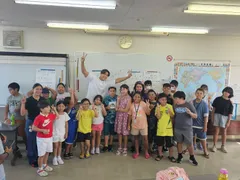 「日本語補修教室に通う子どもたちと笑顔で記念撮影する當間ローズ(湖西国際交流協会にて、2025年8月18日)」