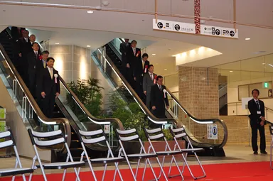 新設のエスカレーターで入場する登壇者ら