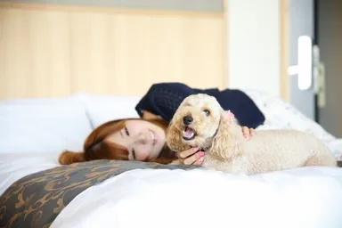 ワンちゃんと一緒にベッドで寛ぐ