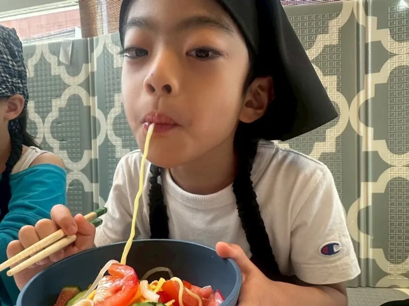 自分の作った料理を食べる様子