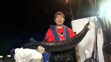 魚を持ち上げる辻本達規(BOYS AND MEN)