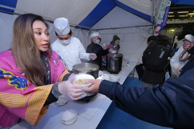 鍋を振る舞うウギャルのLieさん(手前)と伊藤三穂さん(奥)