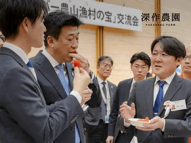 交流会でいちごを召し上がる鈴木農林水産大臣(左)と木原官房長官(中央)、深作農園代表