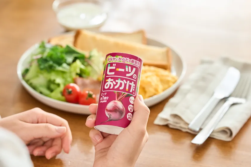 朝食のプレートを前にビーツのおかげを手に持つ様子
