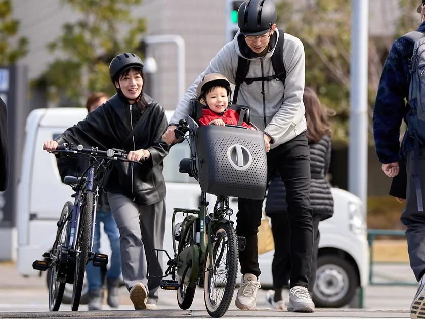 横断歩道を自転車を押して歩く家族
