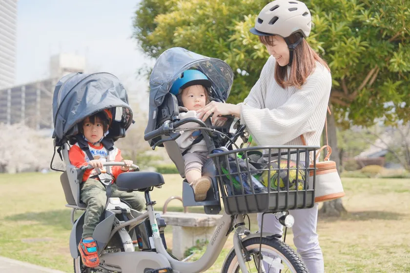 自転車の前後にお子さまを乗せるママ