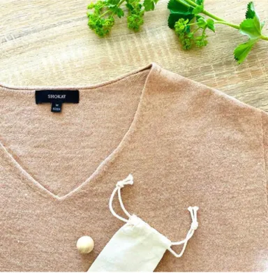 SHOKAYのセーターに添えられた「木のボール」