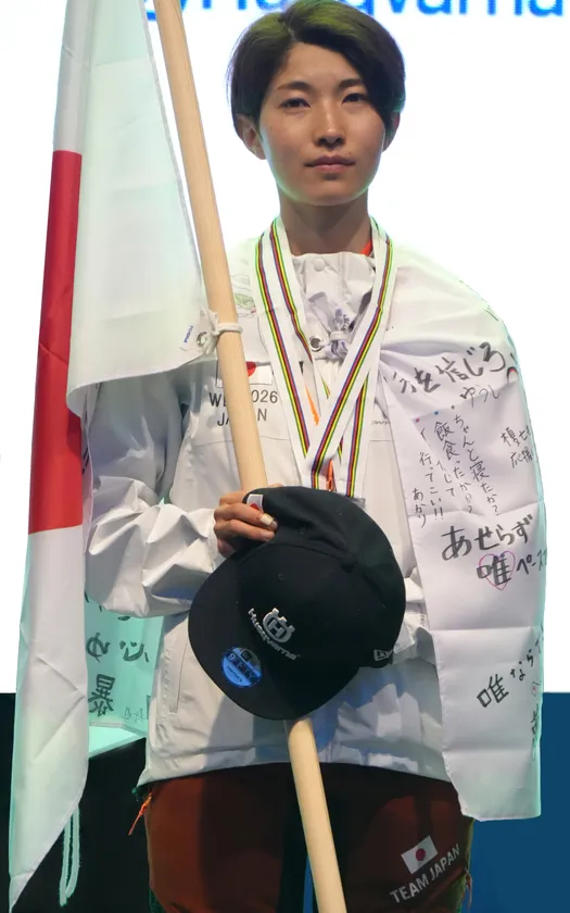個人総合でメダルと国旗を手にした武藤唯選手