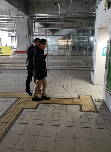 視覚障害当事者(新潟市議会議員の青木 学氏)が実際にナビレンスを利用しているところ