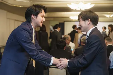 確かな成長を握手に込めて。仲間の成果を共に喜び合う。