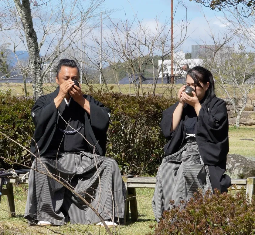 →三日月ノ城(人吉城・国史跡)に鎮座する相良神社で抹茶を召し上がる 兵法タイ捨流 第15代目宗家・上原エリ子さま(写真:右)、兵法タイ捨流 龍泉館館長・山本隆博さま