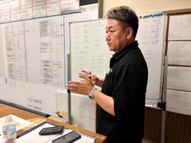 ゆうき総業の独自プログラム『経営アカデミー』で講師を務める結城 伸太郎。日中の現場作業を終えた若手社員9名が、ここで経営学やリーダーシップを学びます。