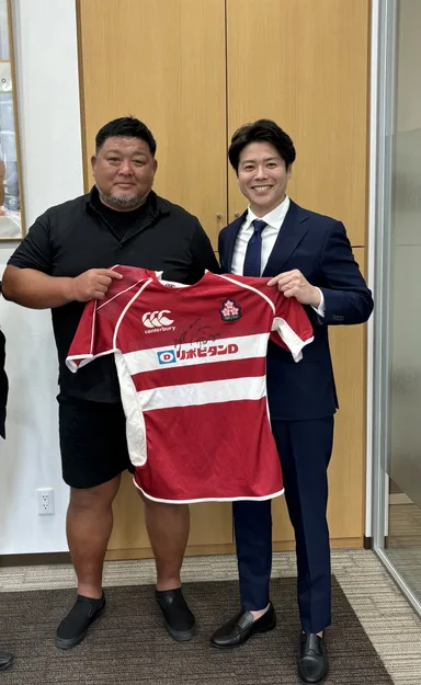 初めてお会いした際、相馬監督(写真左)から贈られたユニフォームを手にする田宮社長(写真右)
