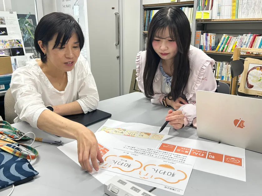 大学教員と学生によるロゴ打ち合わせ風景