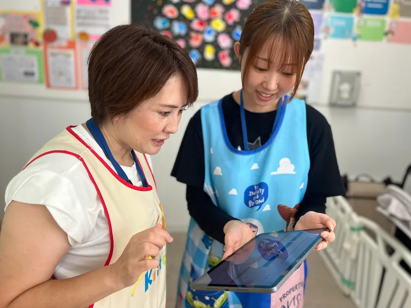 タブレットで園児の情報を確認・共有する保育士