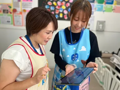 タブレットで園児の情報を確認・共有する保育士