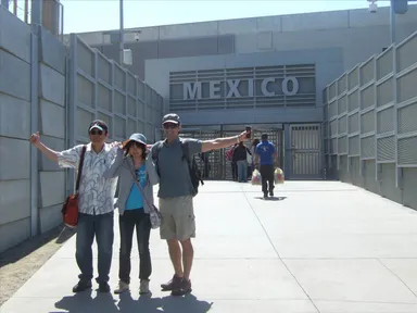 アメリカ・サンディエゴにてメキシコとの国境付近で記念写真を撮る旅行者