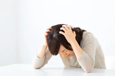 頭を抱えるママ